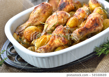 Fresh from the oven: Baked chicken drumsticks with small potatoes and onions Fresh from the oven: Baked chicken drumsticks with small potatoes and onions 58588689