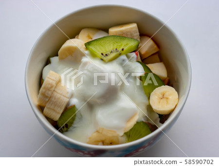 Yogurt in a bowl with cranberries and spoon isolated on white background Yogurt in a bowl with cranberries and spoon isolated on white background 58590702