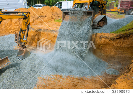 Yellow wheel unloading gravel at construction work Yellow wheel unloading gravel at construction work 58590973