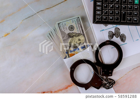 Handcuffs on a set of fingerprints file, money 58591288