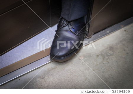 A vicious businessman who puts his feet in the entrance 58594309