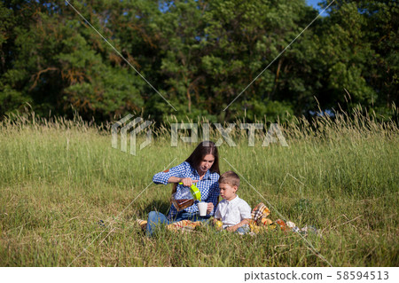 Mom and son eat in park picnic in nature family 58594513