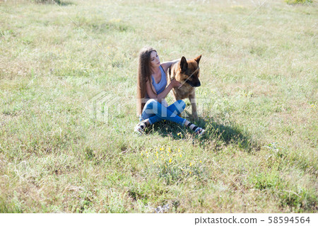 Woman trains German Shepherd in park on walk 58594564