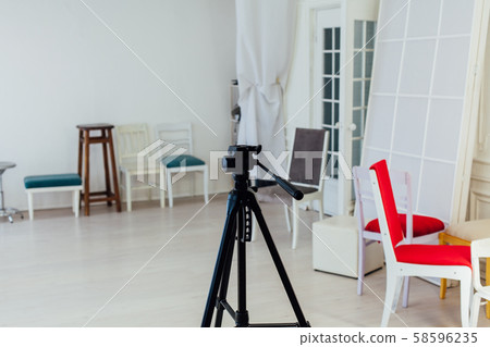 many multicolored chairs stand in the white room in photostudio 58596235
