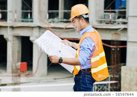 Smiling foreman checking blueprint Smiling foreman checking blueprint 58597644