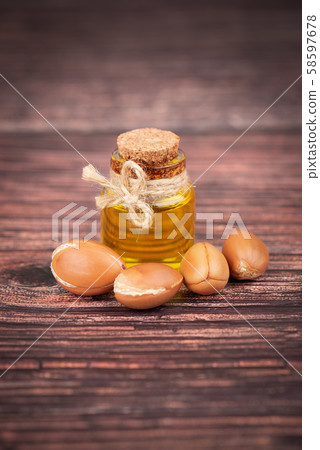 Argan oil, on wooden background. Argan nuts and seeds, for cosmetic and beauty products. Natural 58597678