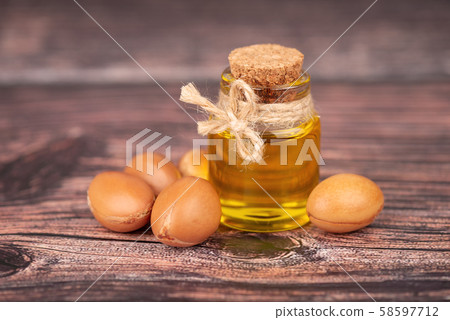 Argan oil, on wooden background. Argan nuts and seeds, for cosmetic and beauty products. Natural 58597712