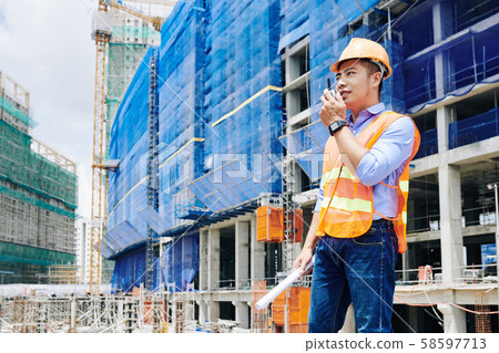Contractor using walkie-talkie for communication 58597713