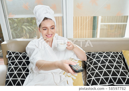 Woman watching tv at home 58597782