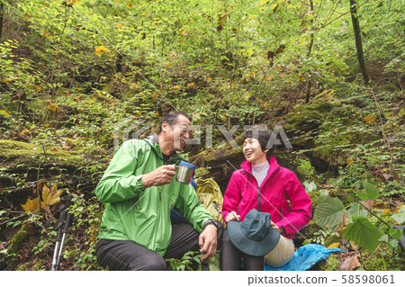 Trekking senior couple enjoying a forest bath 58598061
