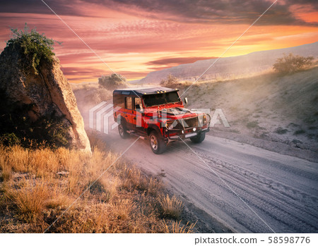 Red off-road car on a dusty road Red off-road car on a dusty road 58598776