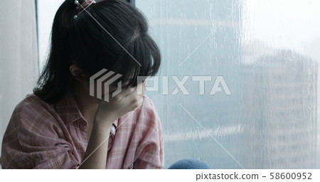 woman cry near by window 58600952