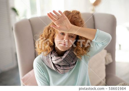 Woman suffering from headache and high body temperature Woman suffering from headache and high body temperature 58601984