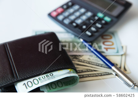 Currency in the wallet and on the table. Currency in the wallet and on the table. 58602425
