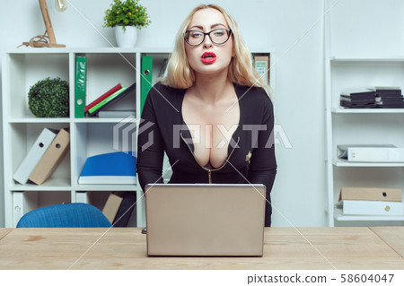 Young woman secretary sits at a table in the Young woman secretary sits at a table in the 58604047