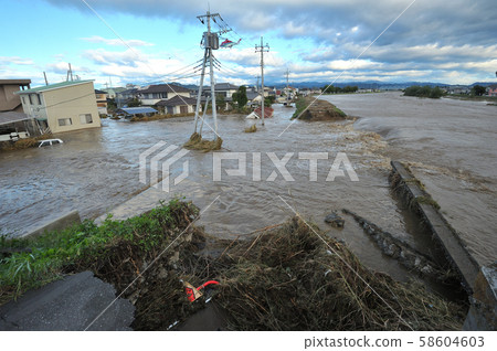 The Akiyama River that was flooded and destroyed by Typhoon No. 19 and the muddy stream flowing into the residential area 58604603