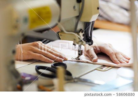 Woman sewing on sewing machine Woman sewing on sewing machine 58606880