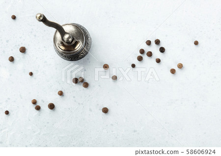 Allspice, Jamaican pepper. Scattered peppercorns with a vintage pepper mill, shot from above with Allspice, Jamaican pepper. Scattered peppercorns with a vintage pepper mill, shot from above with 58606924
