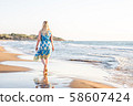 beautiful plus size adult woman enjoys summer vacation by walking along the sandy beach 58607424