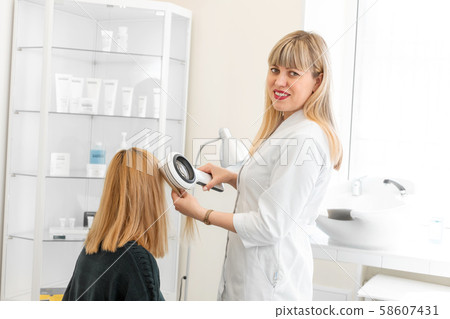 A trichologist examines the condition of the hair 58607431
