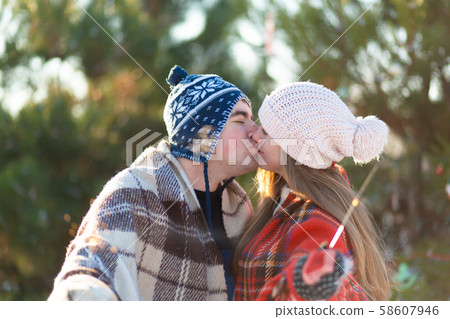 A loving couple in warm plaids kisses holding A loving couple in warm plaids kisses holding 58607946