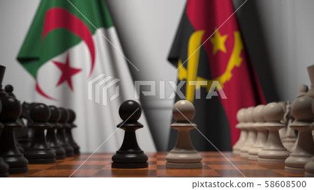 Flags of Algeria and Angola behind pawns on the chessboard. Chess game or political rivalry related 58608500