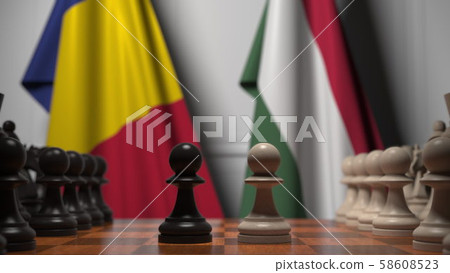 Flags of Romania and Hungary behind pawns on the chessboard. Chess game or political rivalry related 58608523