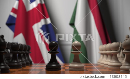 Flags of Great Britain and Hungary behind pawns on the chessboard. Chess game or political rivalry Flags of Great Britain and Hungary behind pawns on the chessboard. Chess game or political rivalry 58608543