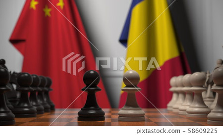 Flags of China and Romania behind pawns on the chessboard. Chess game or political rivalry related Flags of China and Romania behind pawns on the chessboard. Chess game or political rivalry related 58609225