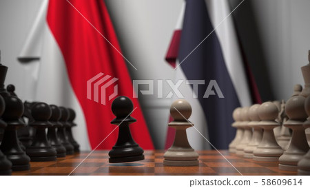 Flags of Indonesia and Thailand behind pawns on the chessboard. Chess game or political rivalry Flags of Indonesia and Thailand behind pawns on the chessboard. Chess game or political rivalry 58609614