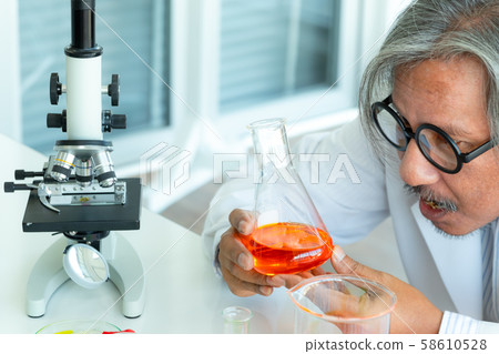 Senior male supervisor doing experiments and Senior male supervisor doing experiments and 58610528
