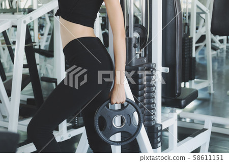 Beautiful women working out in gym alone with Beautiful women working out in gym alone with 58611151