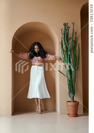Passionate woman in trendy clothes standing in niche of wall 58613039
