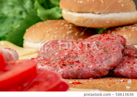 Process of cooking homemade burgers, meatballs, tomatoes, cheese and other ingredients on a wooden 58613636