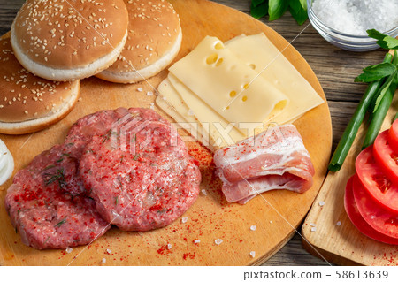 Process of cooking homemade burgers, meatballs, tomatoes, cheese and other ingredients on a wooden 58613639