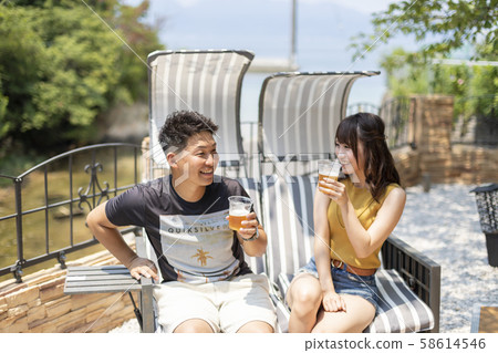 Couple drinking beer in villa garden Couple drinking beer in villa garden 58614546