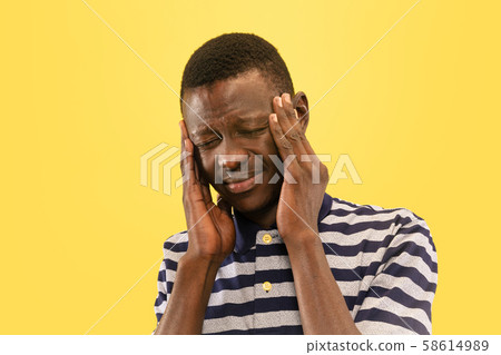 Young african-american man isolated on yellow studio background, human emotions concept. Young african-american man isolated on yellow studio background, human emotions concept. 58614989