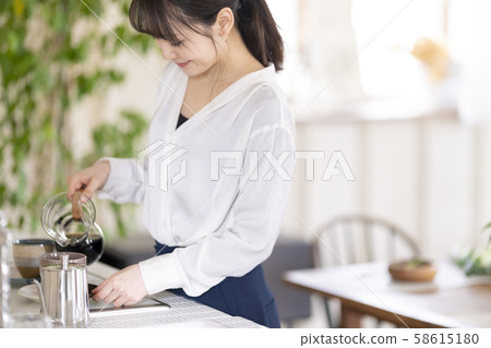 一種女人的生活方式,將木柴從滴頭倒入陶瓷咖啡杯中,在家裡享受著奢華的時光 一種女人的生活方式,將木柴從滴頭倒入陶瓷咖啡杯中,在家裡享受著奢華的時光 58615180