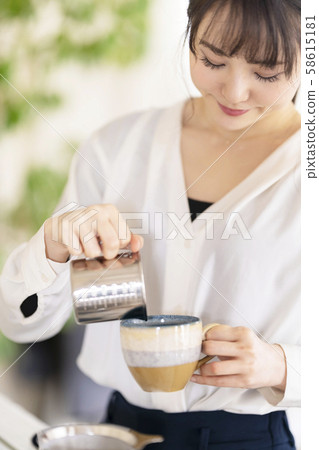 一名女士,在加濃咖啡的奶油中倒入攪打的牛奶,沖泡卡布奇諾咖啡,倒入陶瓷咖啡杯中 一名女士,在加濃咖啡的奶油中倒入攪打的牛奶,沖泡卡布奇諾咖啡,倒入陶瓷咖啡杯中 58615181