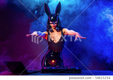 Young sexy woman dj playing music. Headphones and dj mixer on table. 58615258