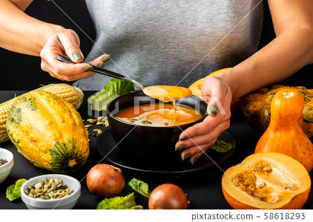 Woman eating homemade pumpkin cream soup. Vegetarian healthy diet food concept. 58618293