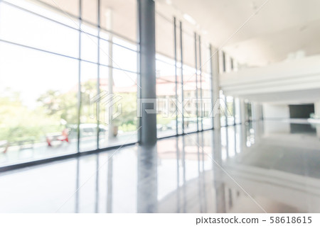 Blur background interior view looking out toward to empty office lobby and entrance doors and glass curtain wall Blur background interior view looking out toward to empty office lobby and entrance doors and glass curtain wall 58618615