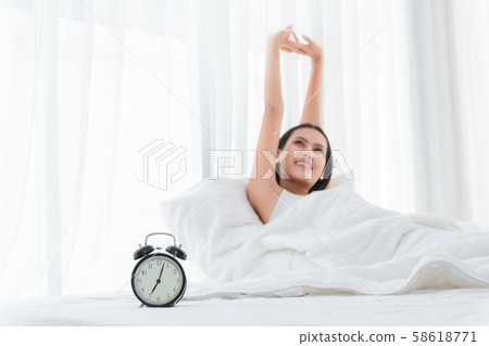 Woman stretching and happy smile on bed in Woman stretching and happy smile on bed in 58618771