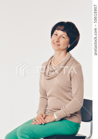 the concept of day rest, relaxation, thoughtfulness-the girl rests sitting on a chair. Calm expression of the woman's face, relaxed posture 58618907