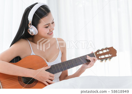 Attractive girl wearing white headphones. 58618949