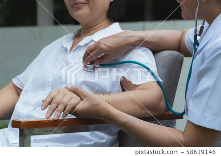 Nurse measure the pressure of elderly outdoors. Nurse measure the pressure of elderly outdoors. 58619146