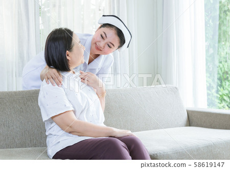 Nurse holding shoulder, see and smile to elderly Nurse holding shoulder, see and smile to elderly 58619147