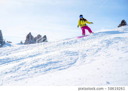Sportive woman in helmet snowboarding at winter resort . Sportive woman in helmet snowboarding at winter resort . 58619261