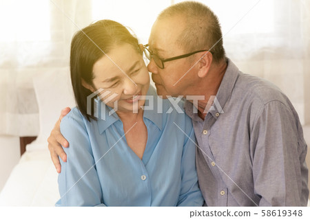 Couple Elderly man kisses cheek woman showing Couple Elderly man kisses cheek woman showing 58619348