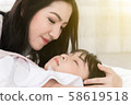 Beautiful mother is embracing her daugher while 58619518